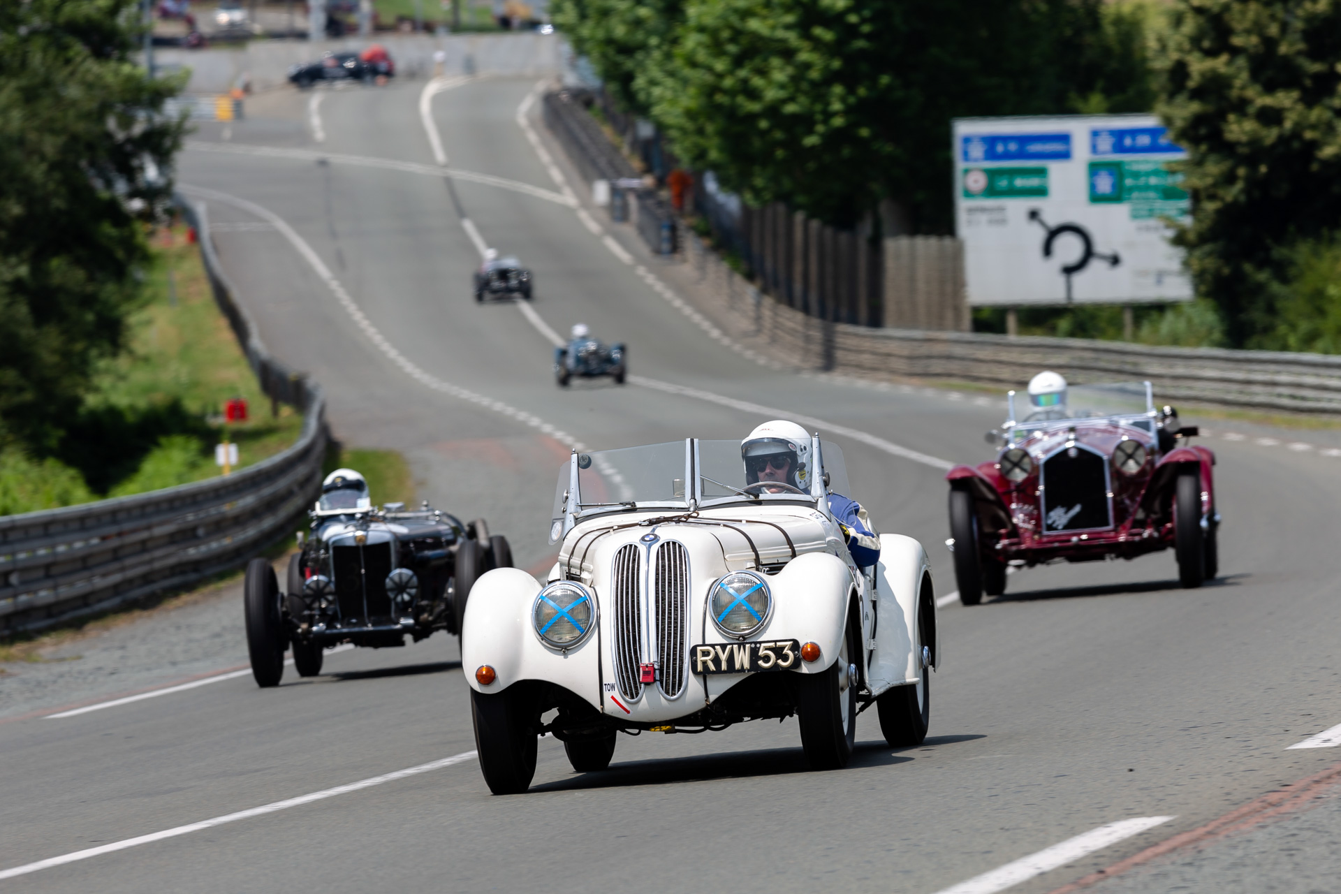 Group of classic cars racing at Le Mans Classic event